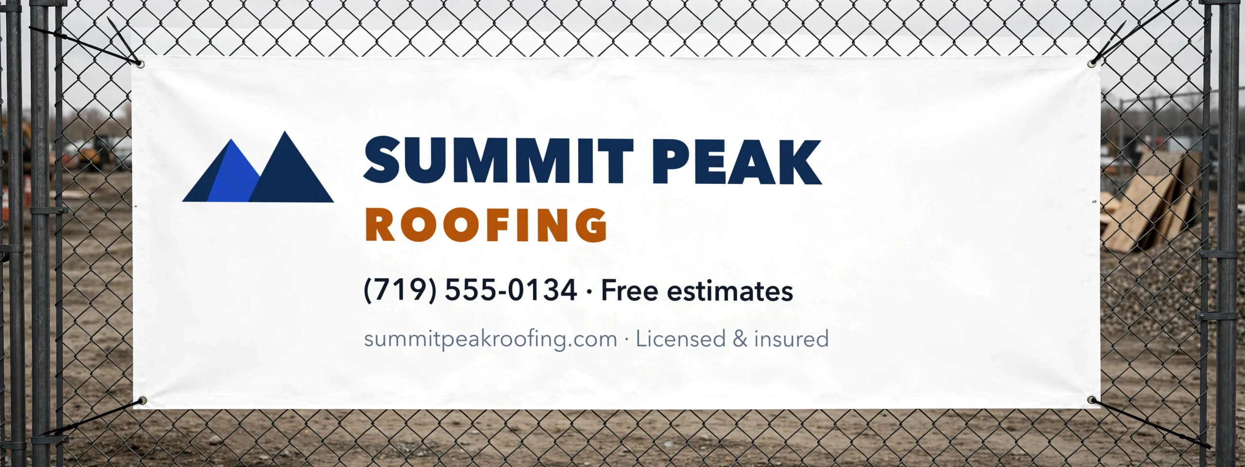 Vinyl banner for a fictional roofing company zip-tied to a chain-link fence at a job site