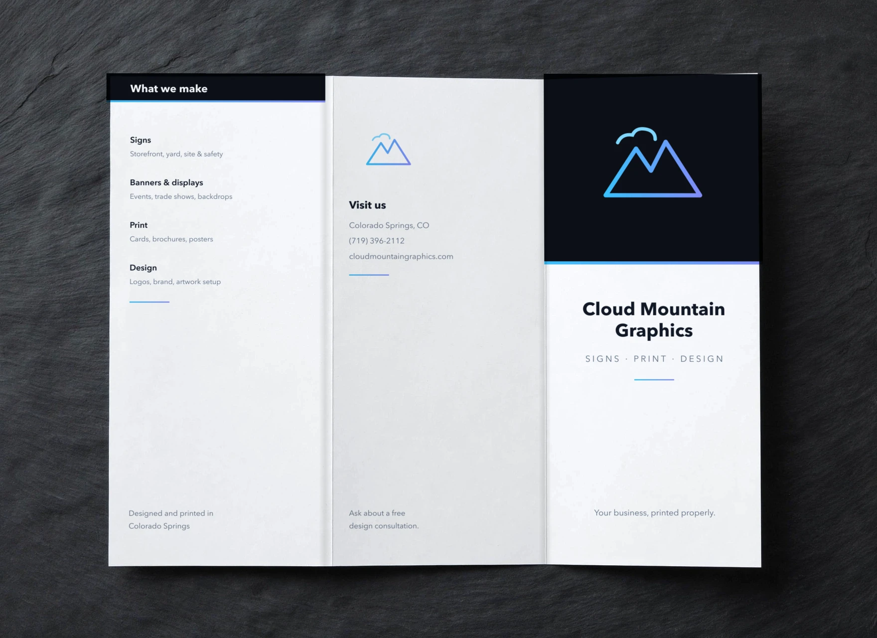 Unfolded tri-fold brochure, outside sheet with the Cloud Mountain cover design, flat on dark slate