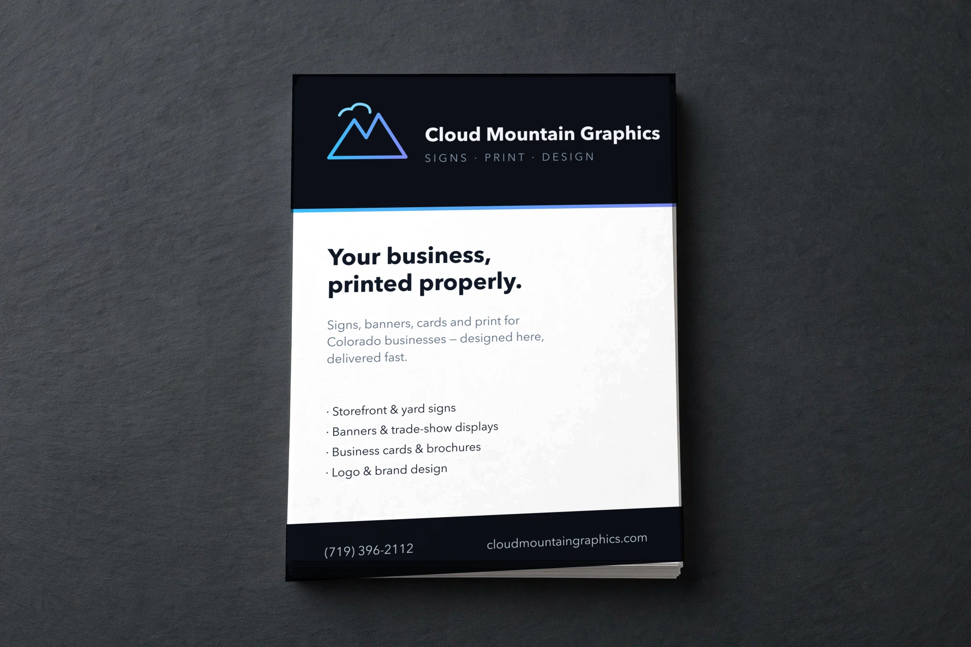 Letter-size flyer with the Cloud Mountain house design on a stack of prints, on dark slate