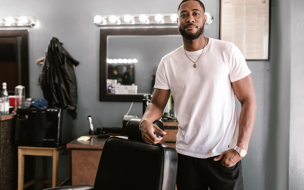 A barber standing in his own shop