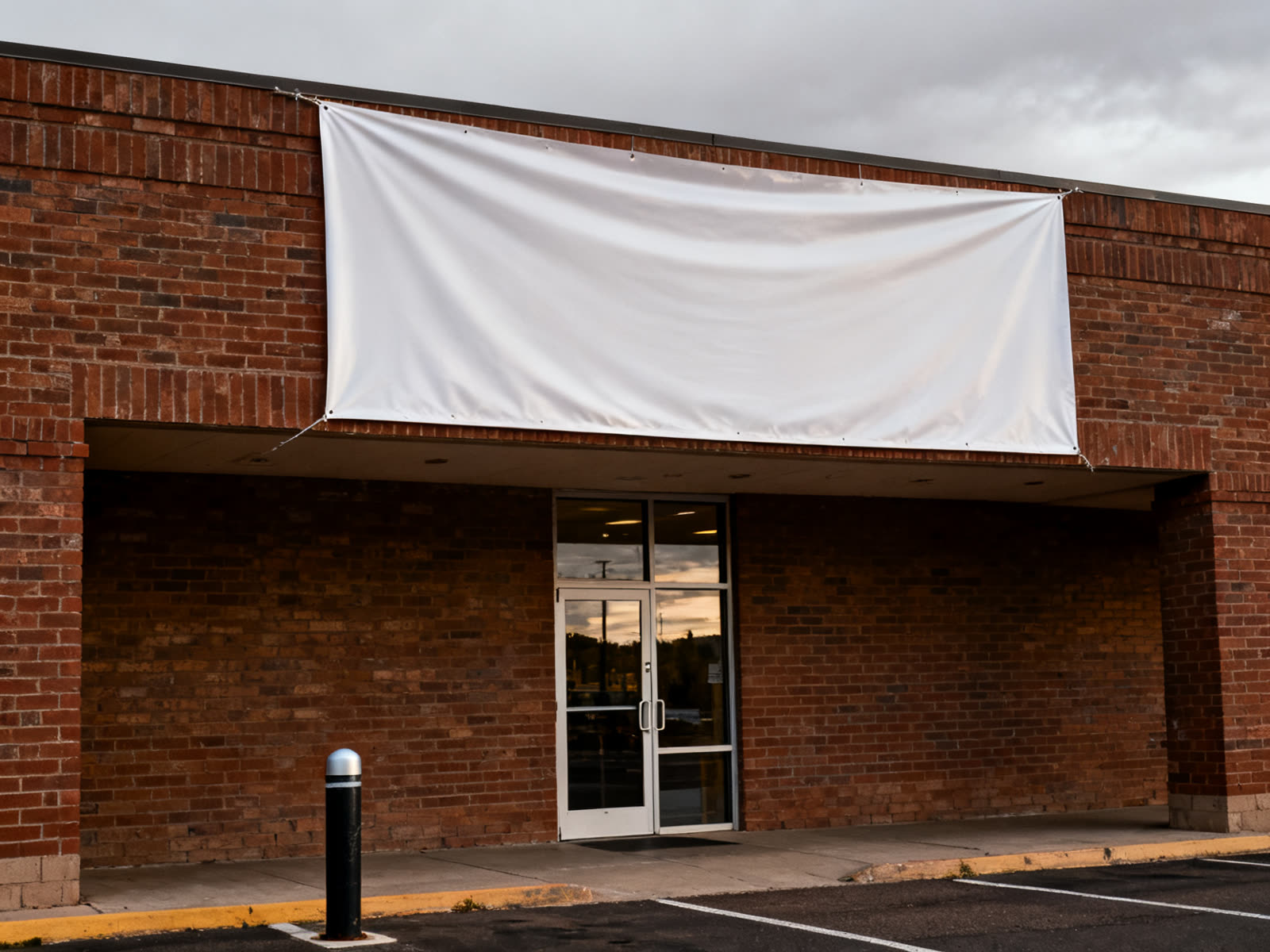 Blank vinyl banner stretched across a brick storefront facade