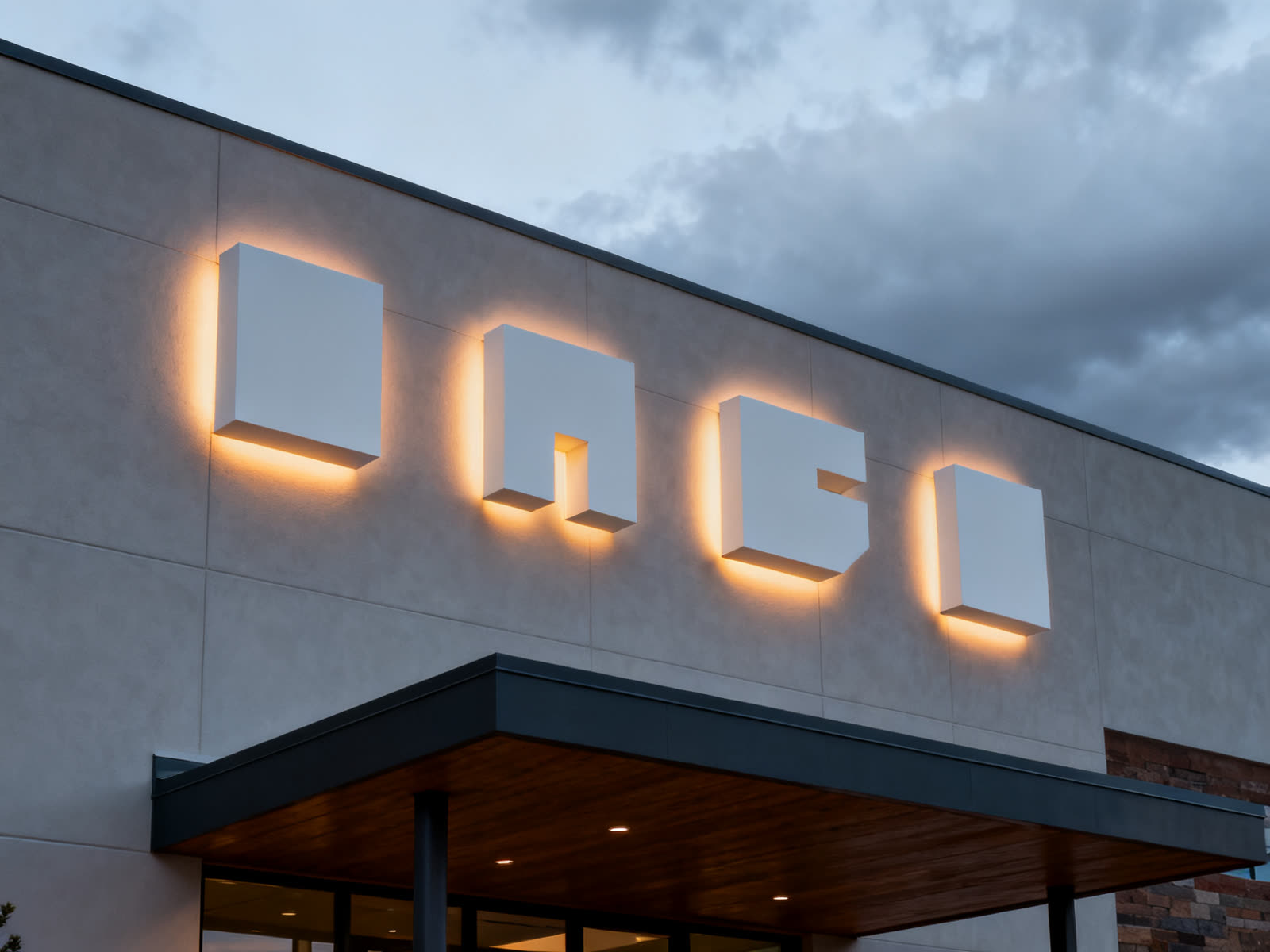 Halo-lit dimensional forms on a building facade at dusk