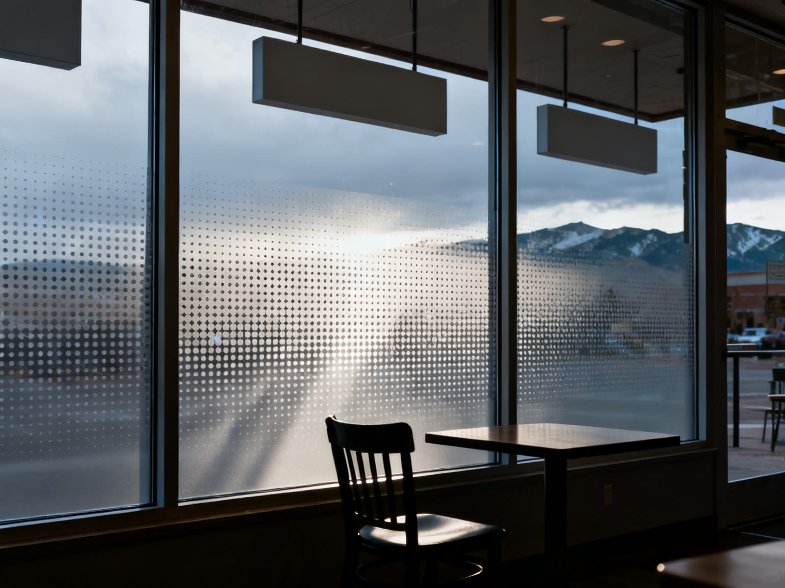 Perforated window film seen from inside, daylight streaming through